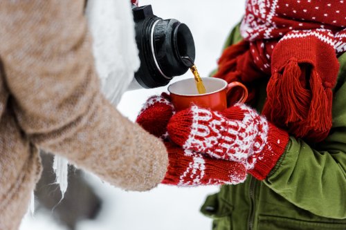 Koffie schenken uit een thermosfles in de winter
